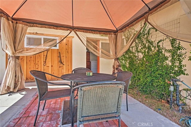 view of patio / terrace with outdoor dining space and a gazebo