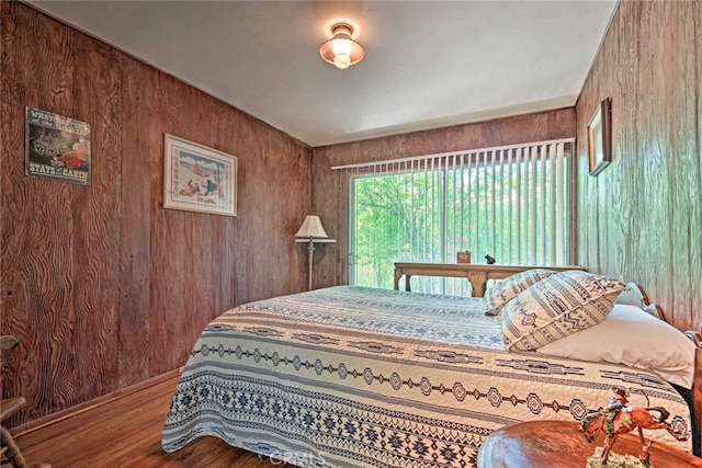 bedroom featuring wooden walls and wood finished floors
