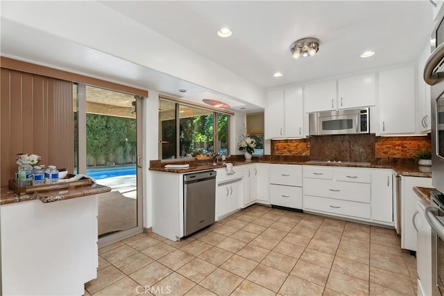 2018 Palisades Dr, Fullerton, CA 92831 - kitchen featuring appliances with stainless steel finishes, light tile patterned floors, tasteful backsplash, and white cabinets