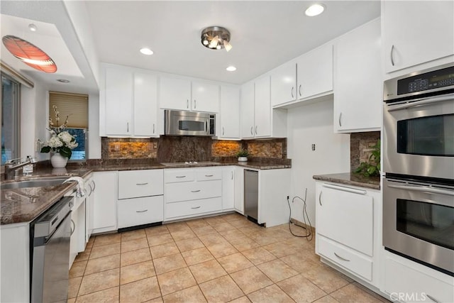2018 Palisades Dr, Fullerton, CA 92831 - kitchen featuring decorative backsplash, light tile patterned floors, stainless steel appliances, a sink, and white cabinetry