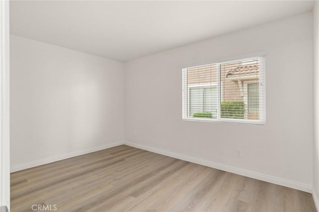 empty room featuring light wood-style floors and baseboards