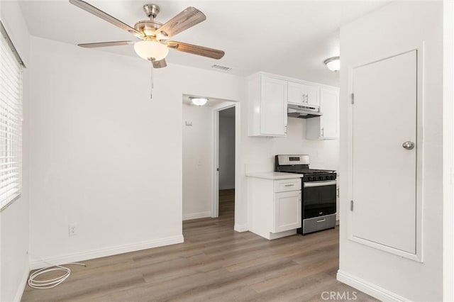 kitchen with gas stove, visible vents, white cabinets, and under cabinet range hood