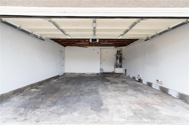 garage with a garage door opener, secured water heater, and baseboards