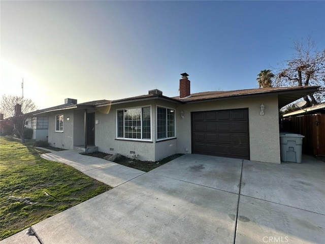 ranch-style home featuring a garage, a chimney, stucco siding, and concrete driveway