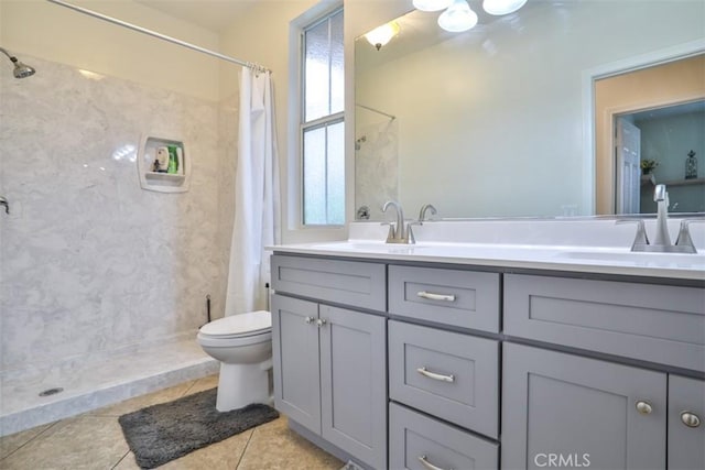 full bath with tile patterned floors, double vanity, a shower with shower curtain, toilet, and a sink