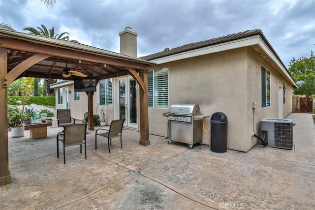 view of patio / terrace featuring central AC unit, ceiling fan, a gazebo, grilling area, and fence