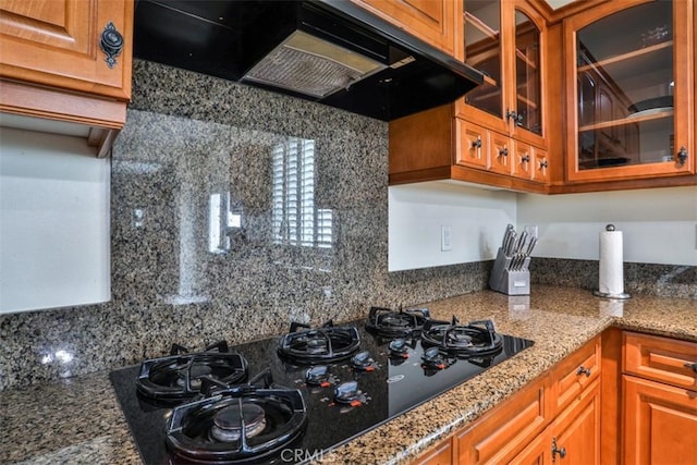 kitchen with ventilation hood, glass insert cabinets, black gas cooktop, and decorative backsplash