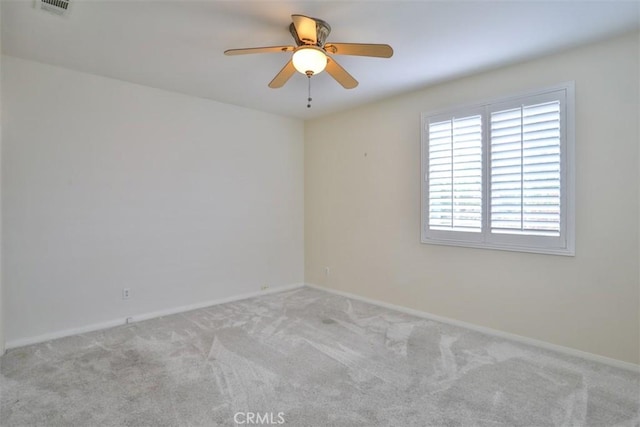 empty room with baseboards, visible vents, a ceiling fan, and carpet flooring