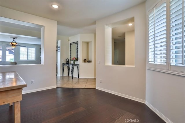 interior space with wood finished floors, a ceiling fan, recessed lighting, and baseboards