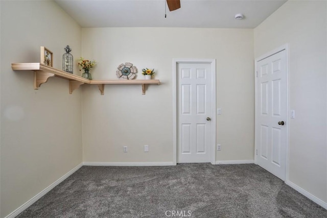 carpeted spare room featuring baseboards and ceiling fan