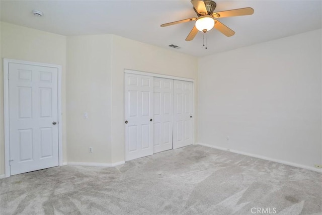 unfurnished bedroom with carpet floors, a closet, ceiling fan, baseboards, and visible vents
