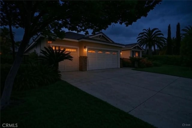 view of front of house with a front lawn, driveway, a garage, and stucco siding