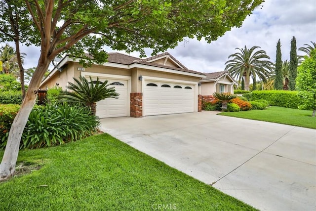 view of front of home with concrete driveway, a front yard, stucco siding, brick siding, and a garage