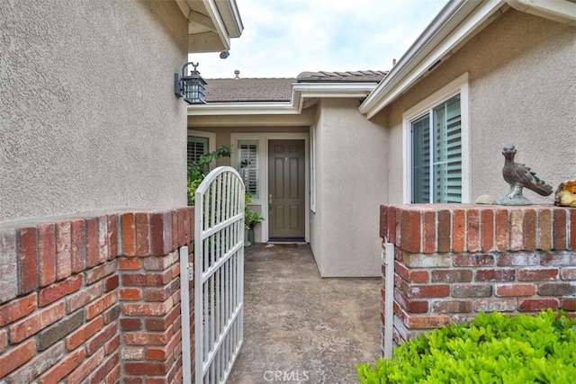 property entrance with stucco siding and a tile roof