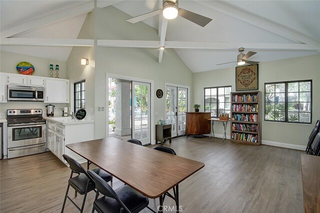 4752 Tiara Dr Unit 103, Huntington Beach, CA 92649 - dining area featuring a ceiling fan, beam ceiling, high vaulted ceiling, wood finished floors, and baseboards