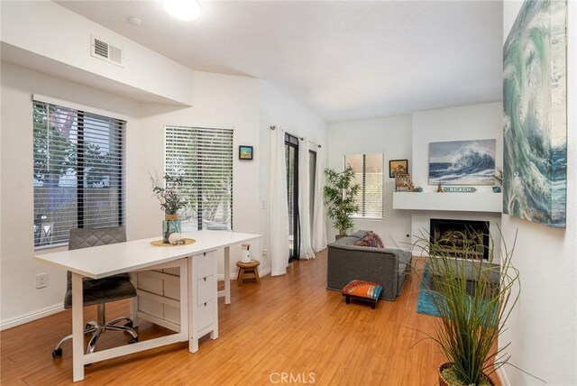 4752 Tiara Dr Unit 103, Huntington Beach, CA 92649 - living area featuring light wood-type flooring, plenty of natural light, a fireplace, and baseboards