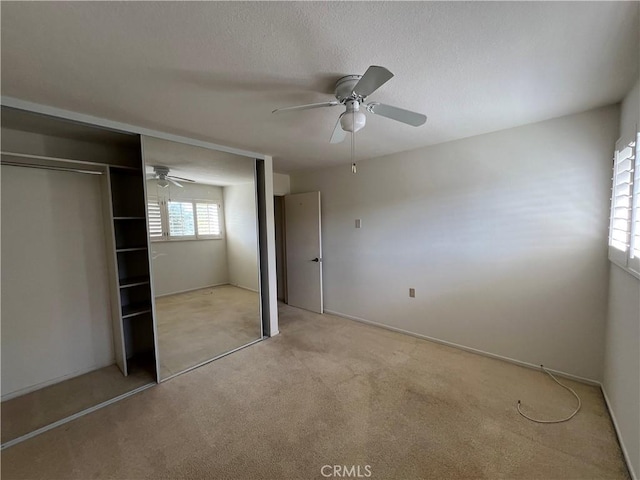 3243 San Amadeo Unit 2H, Laguna Woods, CA 92637 - unfurnished bedroom with a ceiling fan, light carpet, and a closet