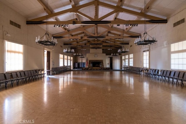 3243 San Amadeo Unit 2H, Laguna Woods, CA 92637 - miscellaneous room featuring visible vents, a fireplace with raised hearth, high vaulted ceiling, and a notable chandelier