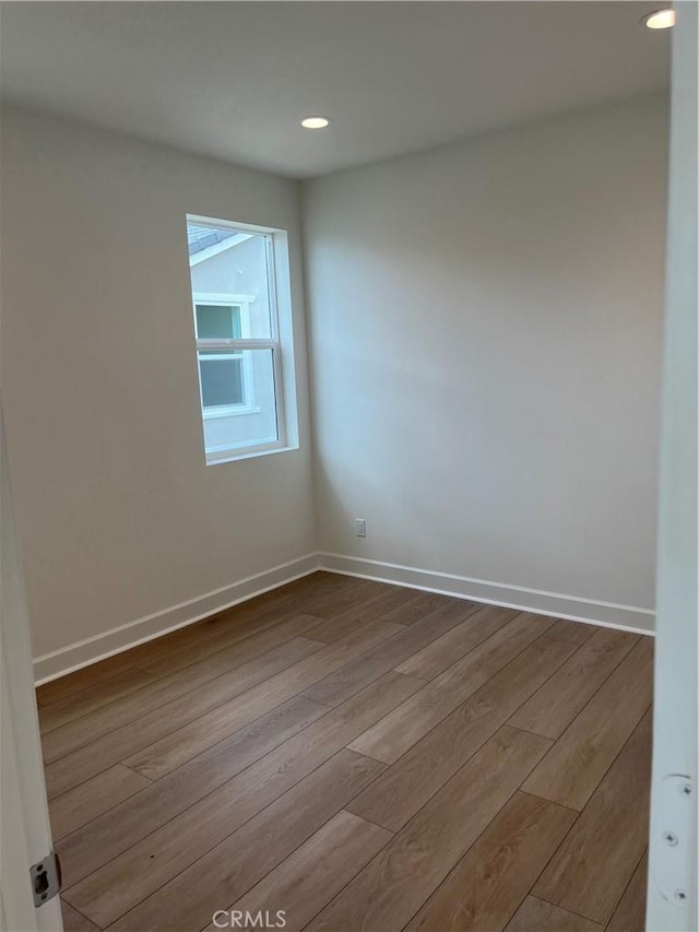 unfurnished room featuring dark wood-type flooring, recessed lighting, and baseboards