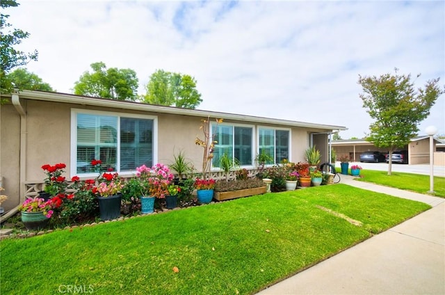 ranch-style house featuring a front yard and stucco siding