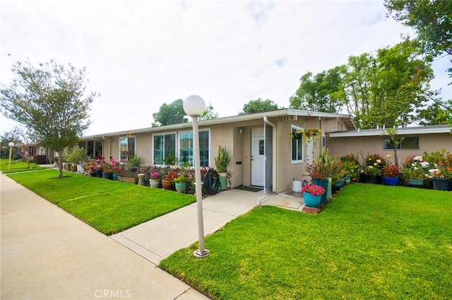 single story home with stucco siding and a front lawn