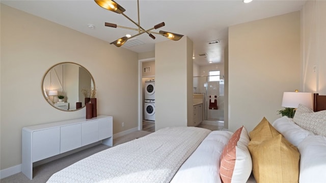 bedroom with connected bathroom, visible vents, baseboards, stacked washer / dryer, and light colored carpet