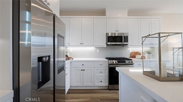 kitchen with wood finished floors, white cabinetry, stainless steel appliances, and light countertops