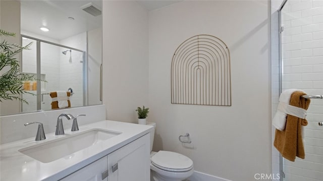 bathroom featuring a shower stall, vanity, toilet, visible vents, and baseboards