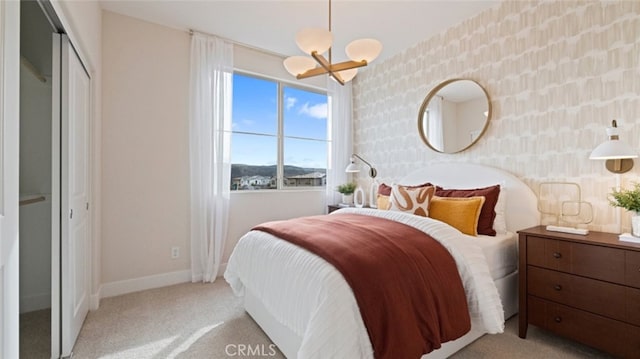 bedroom featuring a notable chandelier, wallpapered walls, light carpet, and baseboards