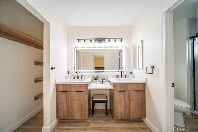 full bathroom featuring a sink, wood finished floors, and two vanities