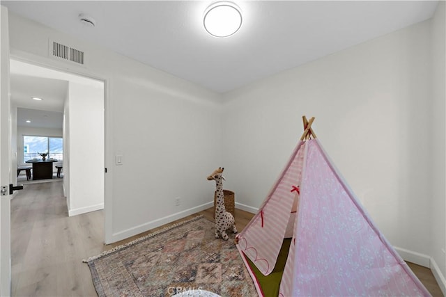 rec room featuring baseboards, visible vents, and wood finished floors