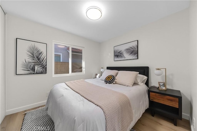 bedroom featuring baseboards and light wood-style flooring