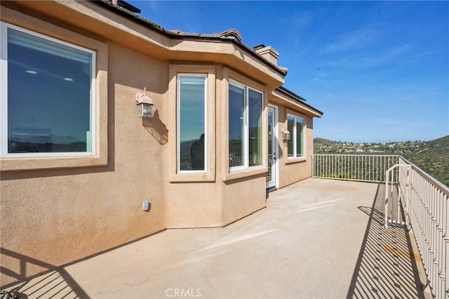 28846 Yosemite Pl, Canyon Lake, CA 92587 - view of side of home with stucco siding, a balcony, and a chimney