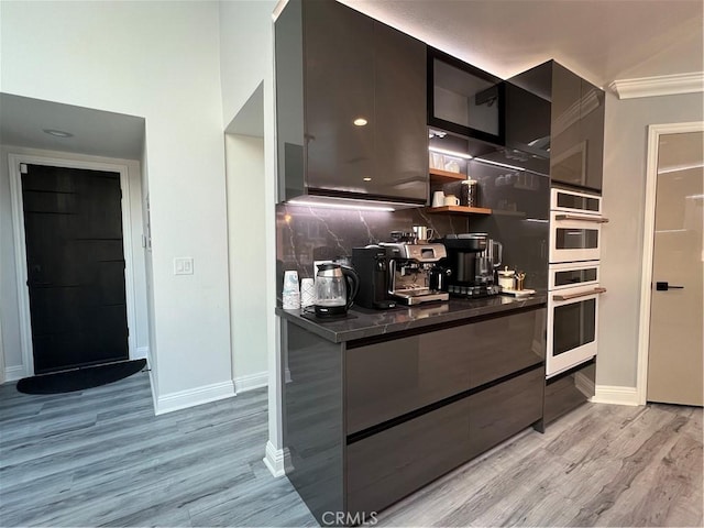 kitchen with baseboards, modern cabinets, backsplash, and dark countertops