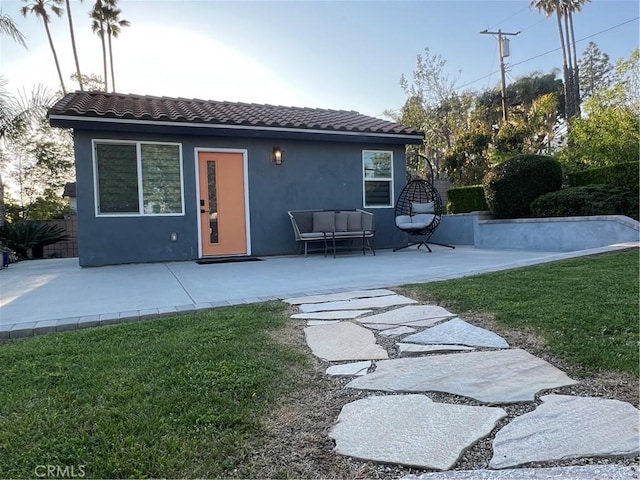 back of house with fence, stucco siding, a patio area, a tiled roof, and a yard