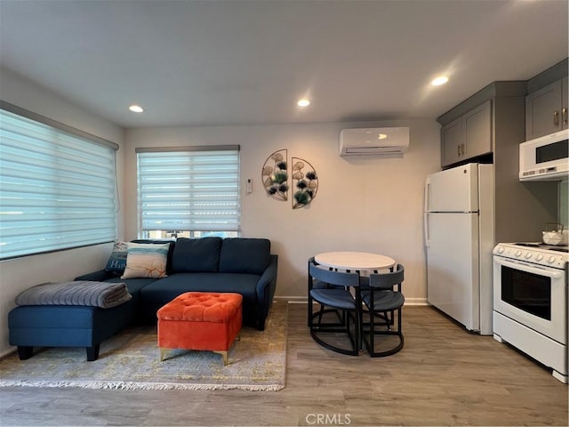 living room featuring recessed lighting, a wall mounted air conditioner, and light wood finished floors