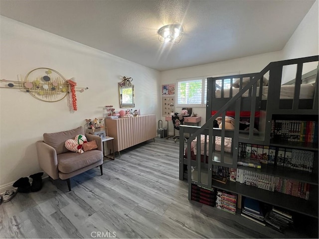living area with baseboards and wood finished floors