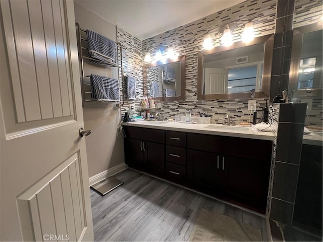 full bath with double vanity, baseboards, visible vents, and a sink