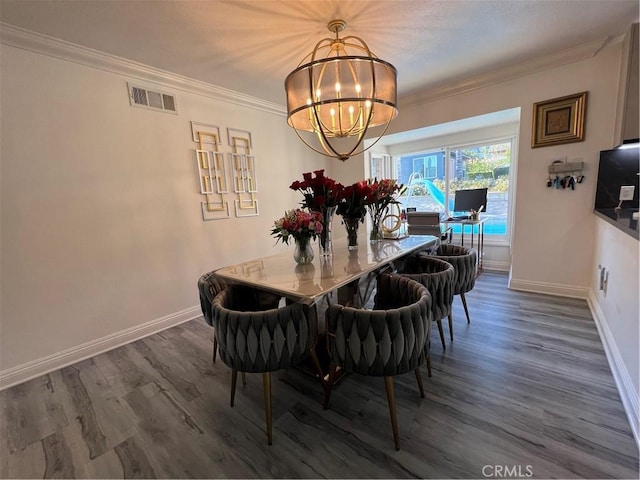 dining space with a notable chandelier, baseboards, wood finished floors, visible vents, and ornamental molding