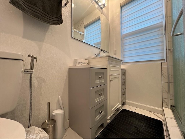 bathroom with an enclosed shower, vanity, tile patterned flooring, and toilet