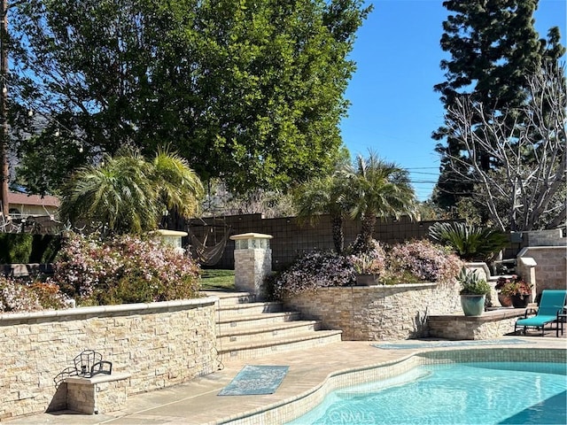 view of swimming pool featuring fence, a fenced in pool, and a patio area