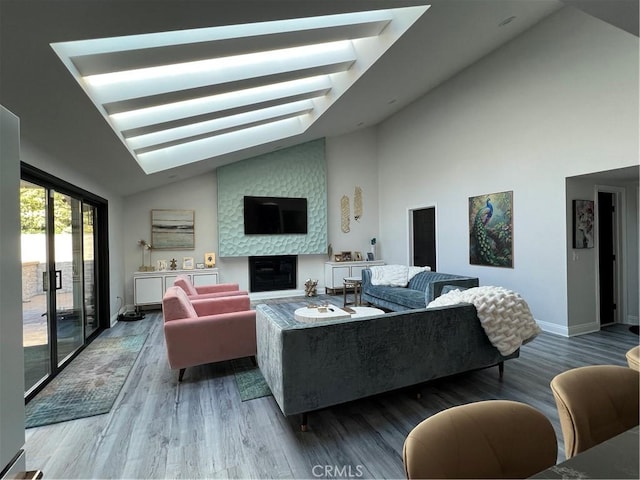 living area featuring baseboards, wood finished floors, high vaulted ceiling, and a large fireplace