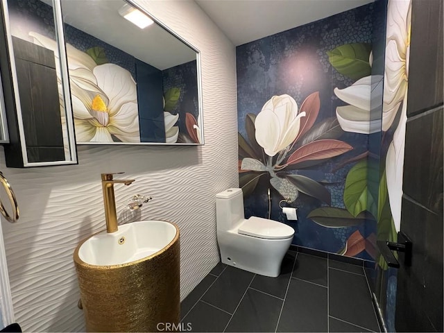 bathroom featuring tile patterned flooring, a sink, toilet, and wallpapered walls