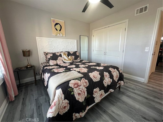 bedroom featuring baseboards, visible vents, wood finished floors, and a closet