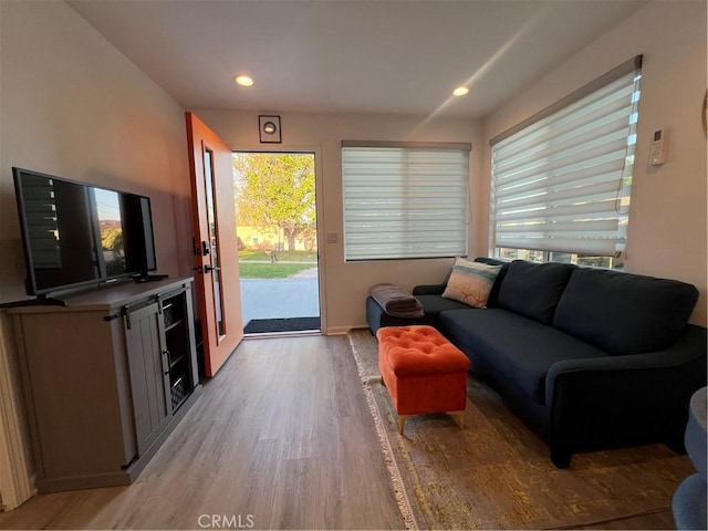 living room featuring baseboards, recessed lighting, and light wood-style flooring