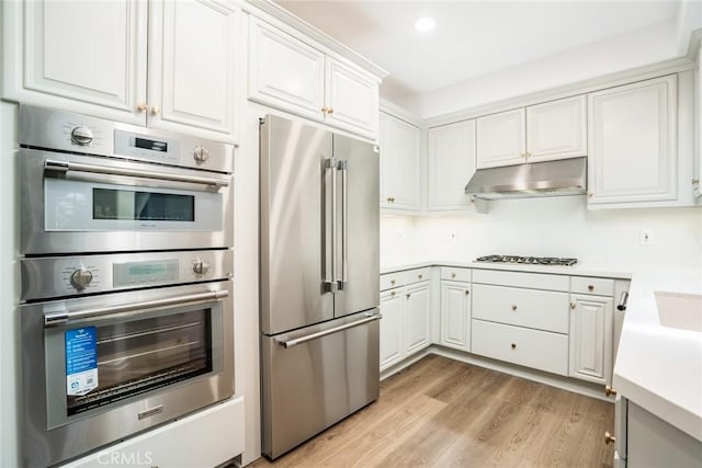 5935 Playa Vista Dr Unit 307, Playa Vista, CA 90094 - kitchen with appliances with stainless steel finishes, light wood finished floors, light countertops, white cabinetry, and under cabinet range hood