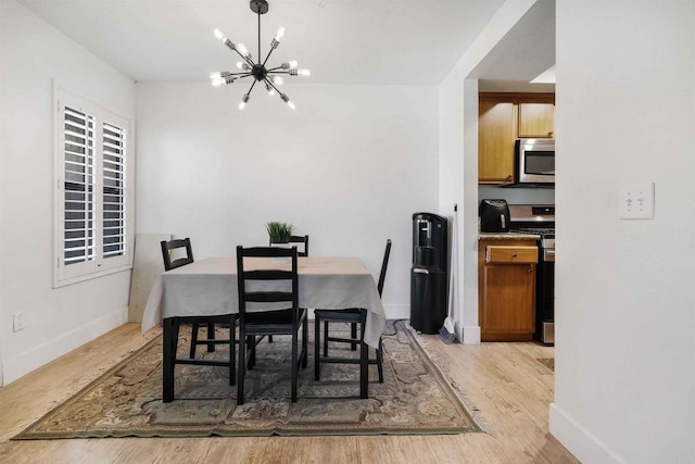 dining room with baseboards, an inviting chandelier, and light wood finished floors
