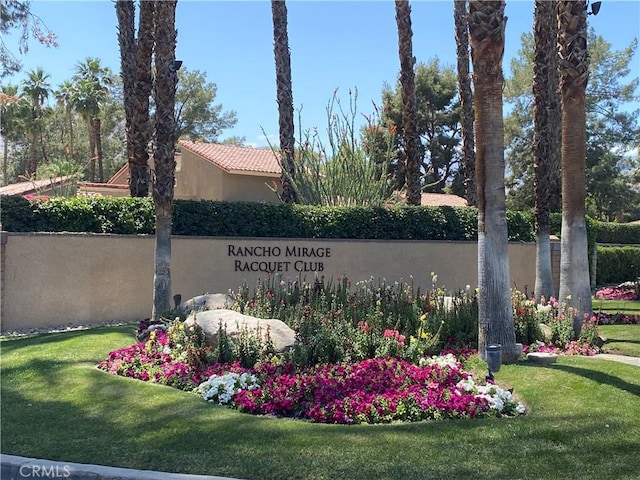 community / neighborhood sign with a lawn and fence