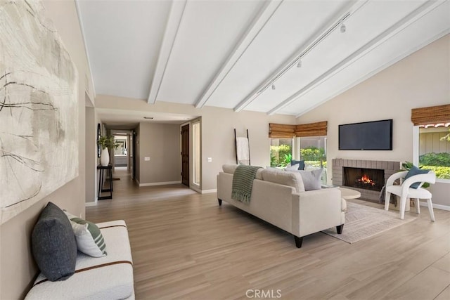 74 Tennis Club Dr, Rancho Mirage, CA 92270 - living room with baseboards, lofted ceiling with beams, a healthy amount of sunlight, and a fireplace