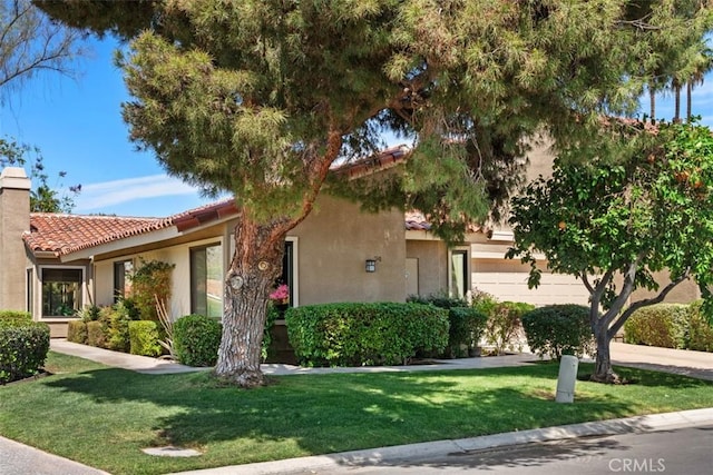 74 Tennis Club Dr, Rancho Mirage, CA 92270 - view of front of home featuring a chimney, a front lawn, stucco siding, and a tile roof